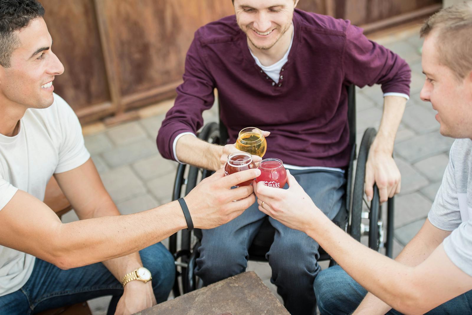 Three friends with different backgrounds enjoying a toast outdoors, highlighting friendship and inclusivity.